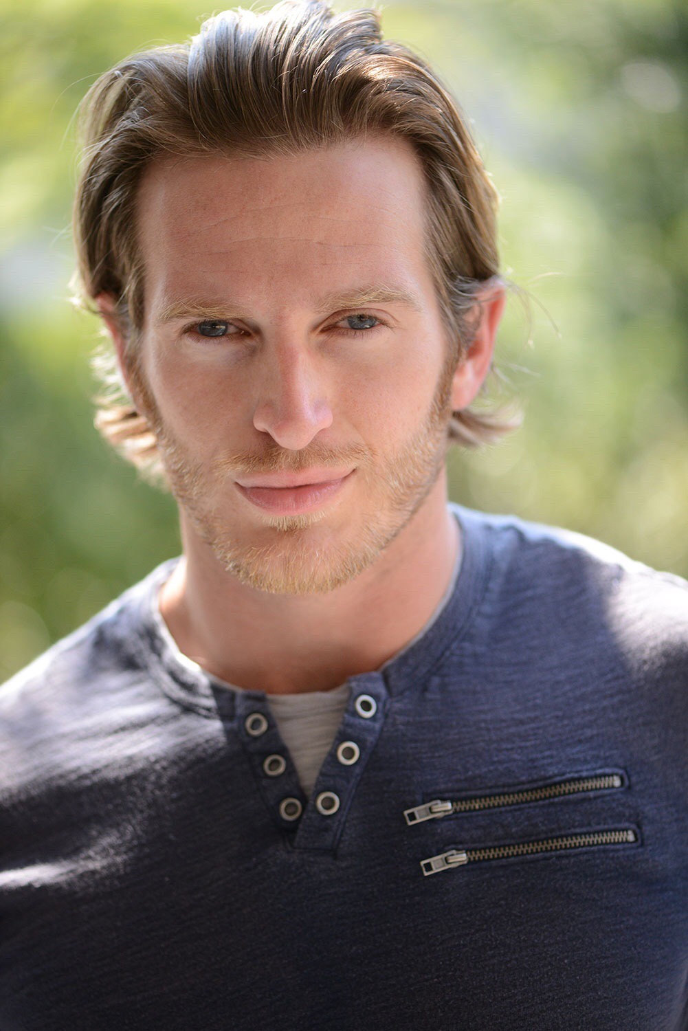 Russell Snipes. Commercial headshot with short hair, warm outdoor light