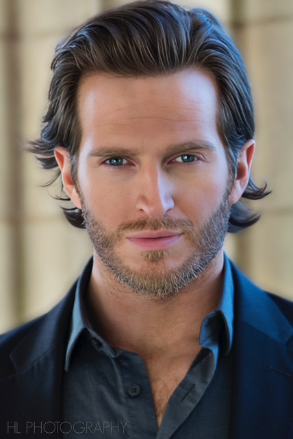 Russell Snipes. Headshot with slicked-back hair in a dark button-up shirt