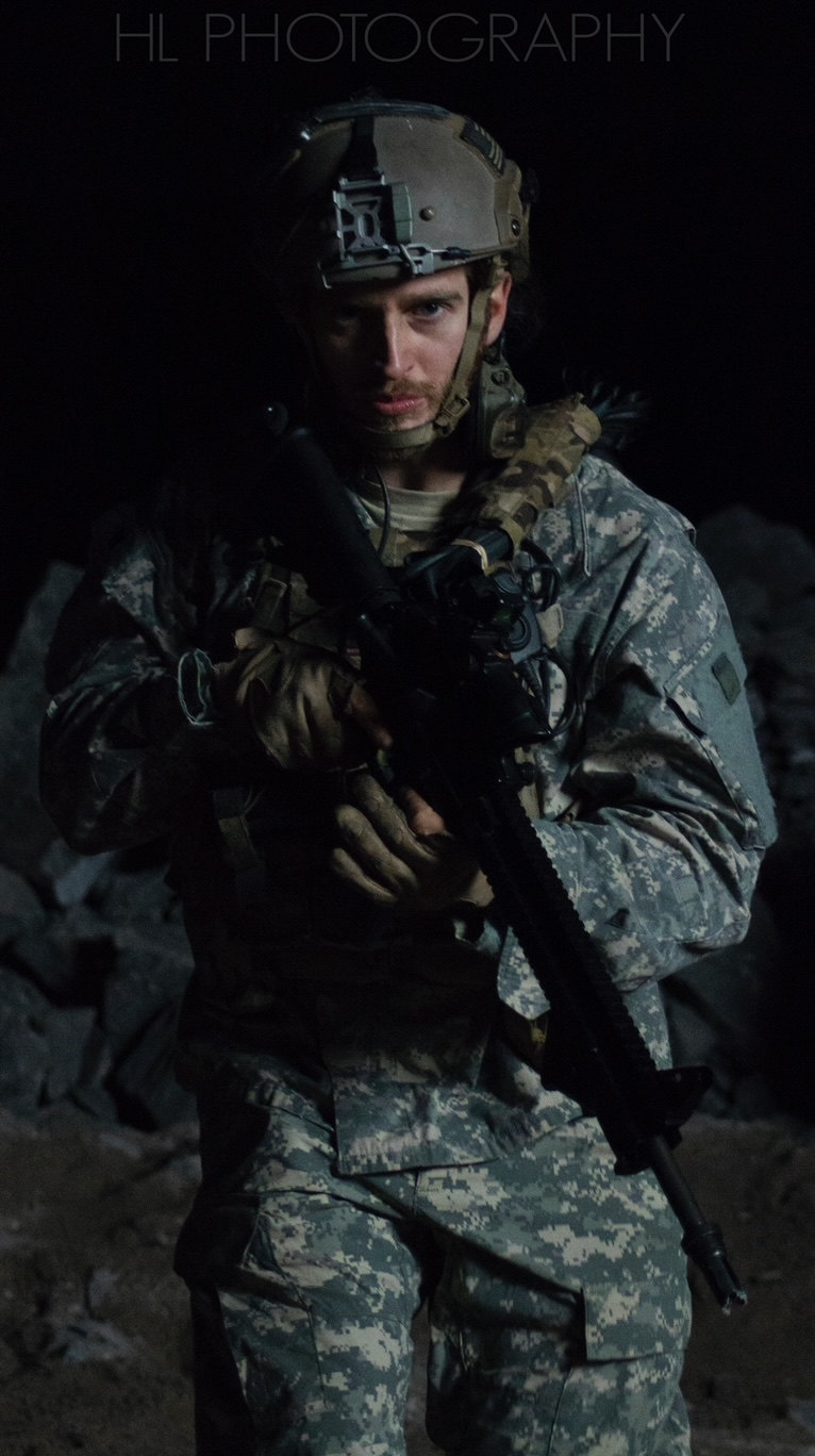 Russell Snipes. Tactical gear and helmet in camouflage, dark backdrop