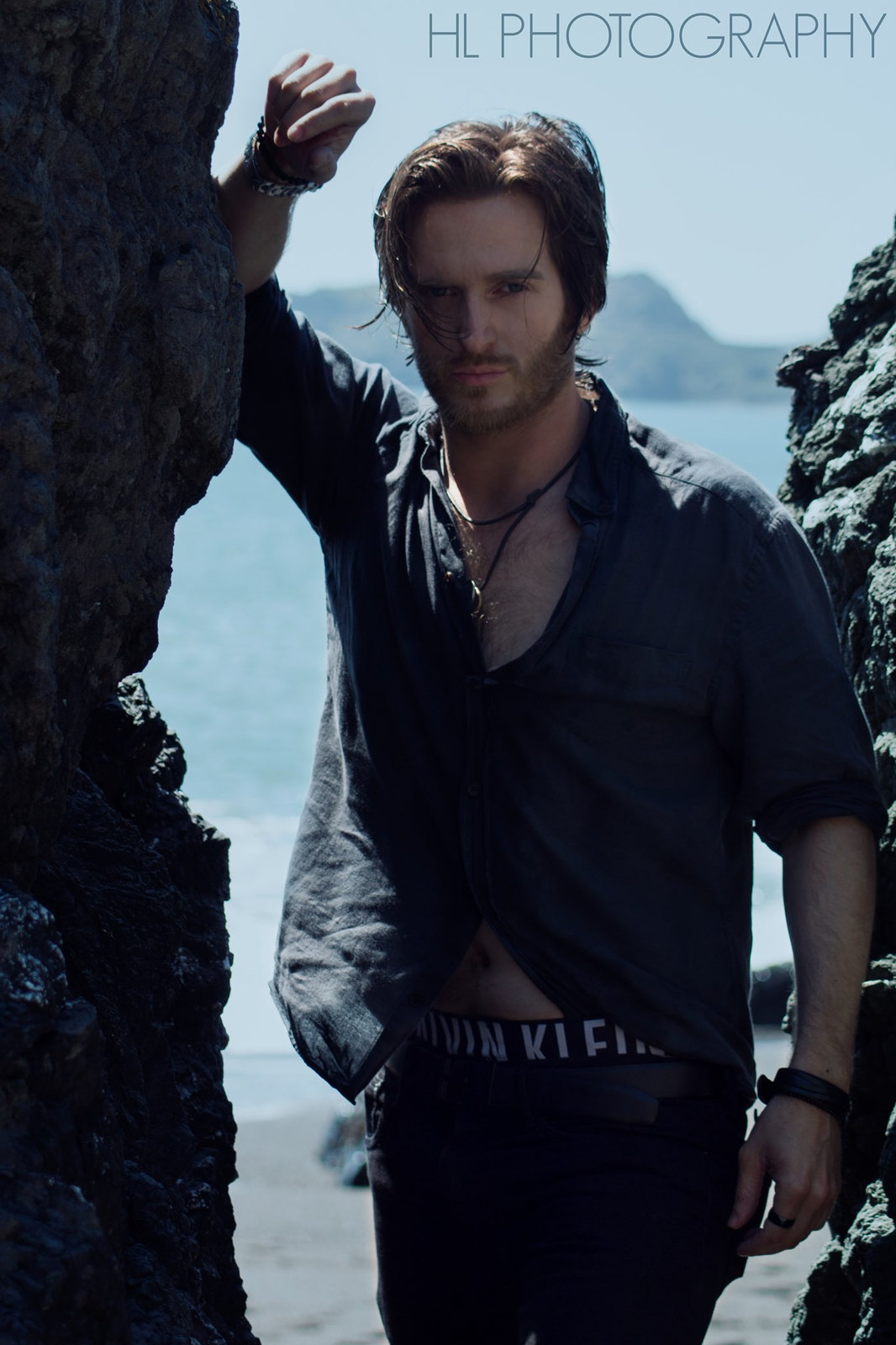 Russell Snipes. Portrait in an open dark shirt by the water