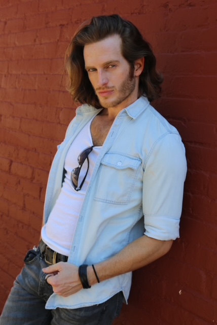 Russell Snipes. Casual look in a light shirt and sunglasses against a red wall